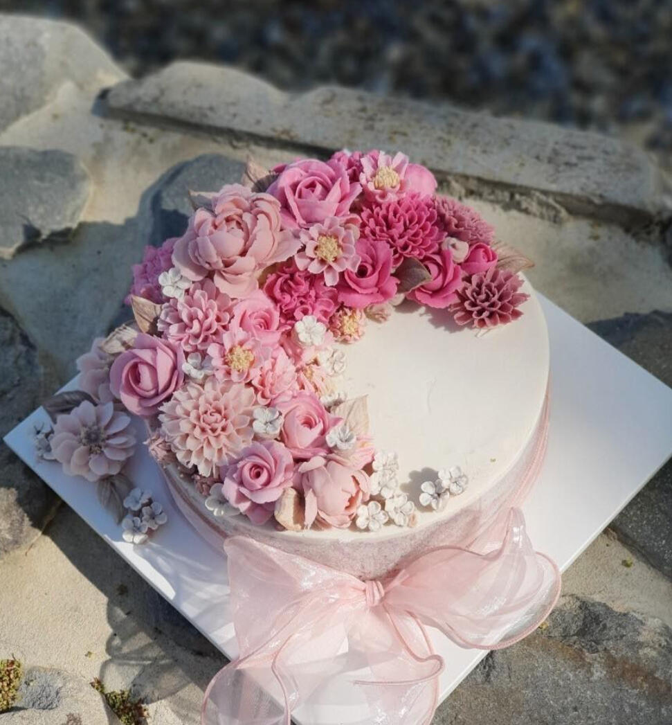 Handcrafted Korean Tteok Cake with Pink Bean Paste Flowers – Korea Craft Studio A beautifully decorated Korean rice cake (tteok) topped with intricate pink and purple bean paste flowers, created during a workshop at Korea Craft Studio in Pyeongtaek.